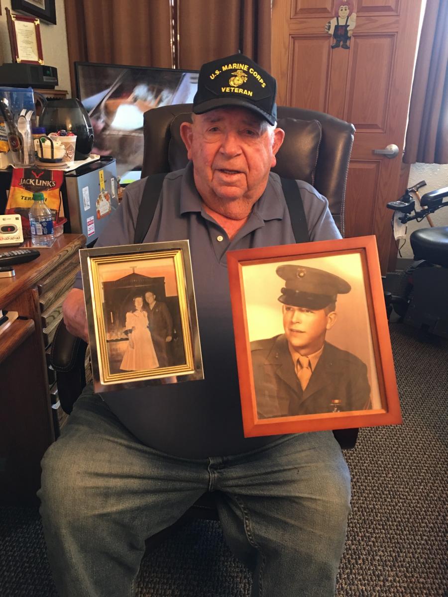 Bill West holding photos