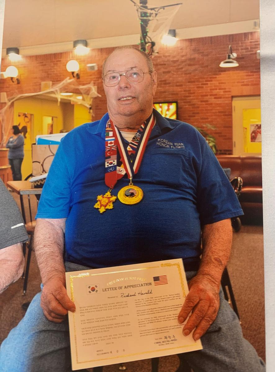 Richard holding certificate from Korean government