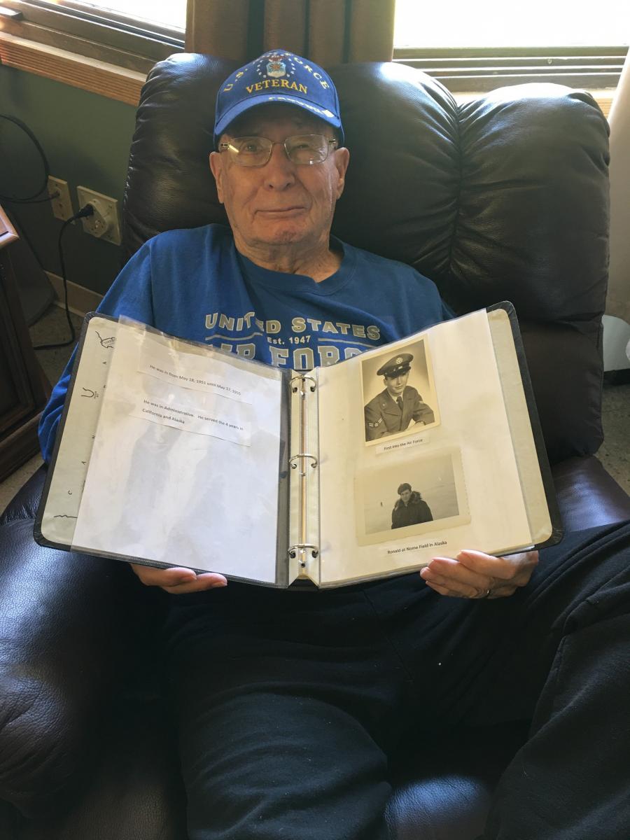 Ronald Dutton holding photos