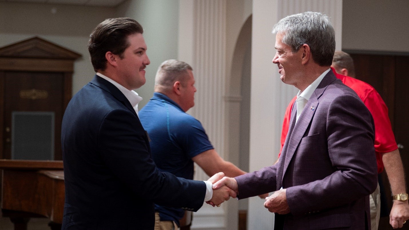 Governor Pillen presents a “Welcome Home” challenge coin to a veteran at the 2024 Welcome Home Dinner. 