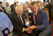 Gov. Pillen presenting State of Nebraska recognition coins to veterans in attendance of the ceremony.