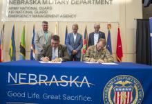 NDVA Director John Hilgert and Nebraska National Guard Adjutant General MG Craig Strong sign an MOU to establish a state veterans service office at Joint Force Headquarters in Lincoln as State Veterans Service Officer Dan Benes, Governor Jim Pillen, and Lieutenant Governor Joe Kelly watch. 