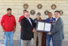 Veterans Cemetery Grants Program Director James Earp (front right) presents the NCA Stewardship Award to Cemetery Manager James Goodwin. Behind them are (from left to right) NVCA public servants Peyton Hornung, Danny Blow, Alisha Coffee, and Jacob Hernandez.