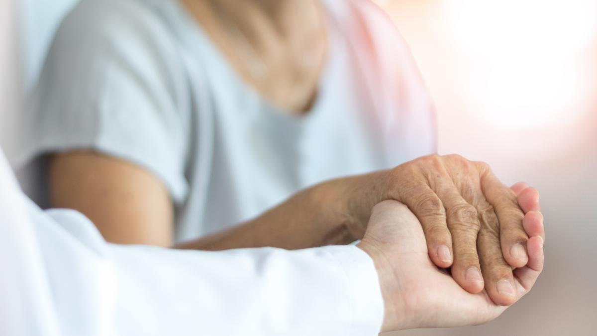 Caregiver holding the hand of an elderly person