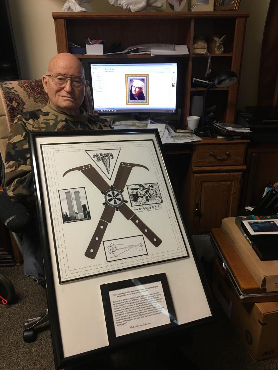 Richard Schaneman pictured with photograph of self in military