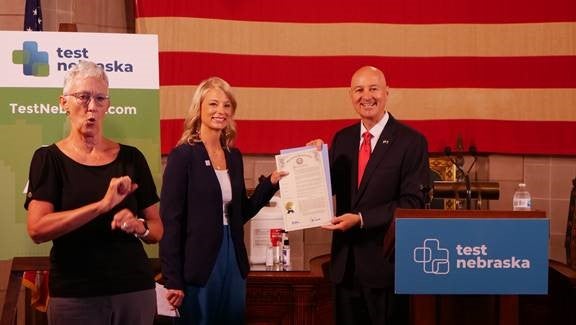 Gov. Ricketts and military caregiver Andrea Dorsey hold up the Hidden Heroes proclamation